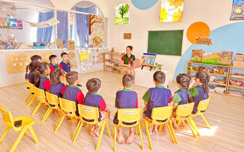 Vòng tròn buổi sáng — các bé ngồi quanh cô trong lớp học